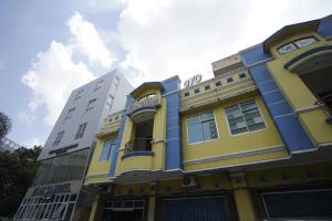 un bâtiment jaune et bleu à côté de certains bâtiments dans l'établissement SUPER OYO 1173 Hotel Shofa Marwah, à Palembang