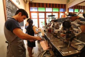 a man standing at a bar in a coffee shop at Little Jasmine by the River in Phitsanulok +35 photos