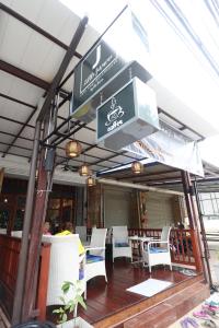 a restaurant with white chairs and tables and signs at Little Jasmine by the River in Phitsanulok