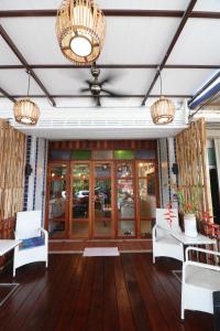 a lobby of a restaurant with white chairs and chandeliers at Little Jasmine by the River in Phitsanulok