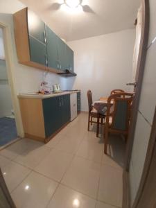 a kitchen with green cabinets and a table and chairs at Apartmani More in Posedarje