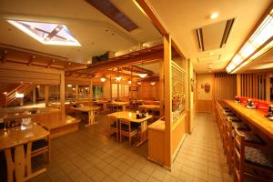 a restaurant with tables and chairs in a room at Hotel Towadaso in Towada