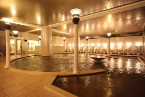 a pool in the middle of a building with lights at Hotel Towadaso in Towada