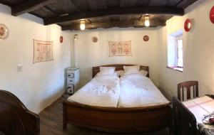 a bedroom with two beds with white sheets at 200 éves vendégház in Balatonalmádi