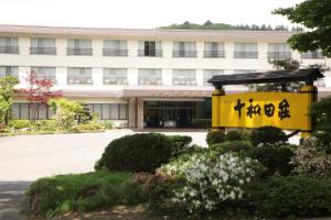 a building with a yellow sign in front of it at Hotel Towadaso in Towada