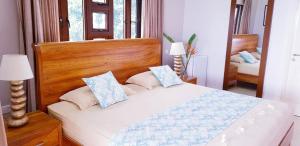 a bedroom with a bed with a wooden headboard and pillows at Calm Sorento in Glacis