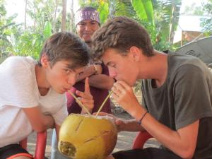 a group of boys looking at a coconut at Kristian Homestay in Bajawa