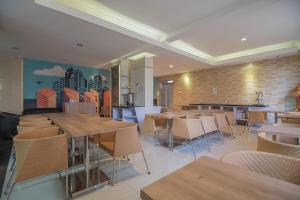 a restaurant with tables and chairs and a mural at RedDoorz At Hotel Arimbi Dewi Sartika Baru in Bandung