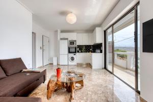 a living room with a couch and a table at Varkiza by the sea in Vari