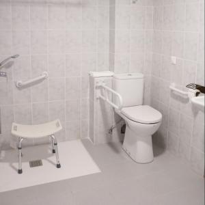 a white bathroom with a toilet and a sink at El Sueño del Infante in Guadalajara