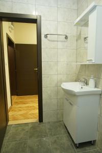 a bathroom with a sink and a shower with a door at Hacijenda in Bajina Bašta