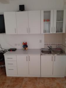 a kitchen with white cabinets and a sink at VASILIJA, studio apartman in Budva +6 photos