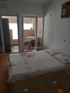 a bedroom with a bed and a room with a table at VASILIJA, studio apartman in Budva