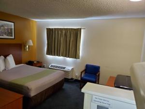 ein kleines Hotelzimmer mit einem Bett und einem Stuhl in der Unterkunft Studio 6-Richmond, VA - I-64 West in Richmond