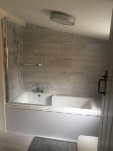 bagno con vasca bianca e lavandino di woodpecker cottage at frog trotters cottages a Hartpury Altre 17 foto