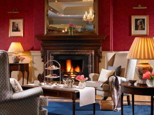 a living room with a fireplace and a table with a cake at Knockranny House Hotel & Spa in Westport