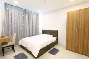 - une chambre avec un lit, un bureau et des rideaux dans l'établissement Baymax Home Apartment 2BR Riverview, à Nha Trang