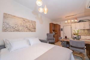 sypialnia z łóżkiem, stołem i krzesłami w obiekcie Casa Aelia, luxury apartment w Korfu