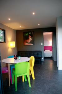a room with a table and chairs and a bed at Gîte La Cerise Qui Rit in La Cresse