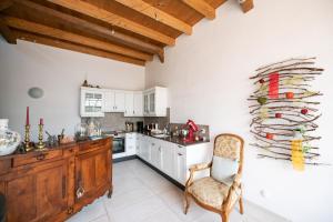 a kitchen with white cabinets and a chair in it at Domaine de la Coteire in Cugy