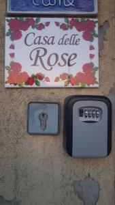 eine Wand mit einem Cisco delle Rose Schild und einem iPod-Ladegerät in der Unterkunft Casa delle Rose Appartamento Gelsomino in San Mauro Pascoli