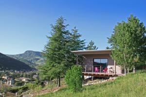 una casa en una colina con sillas en una cubierta en Gîte La Cerise Qui Rit, en La Cresse