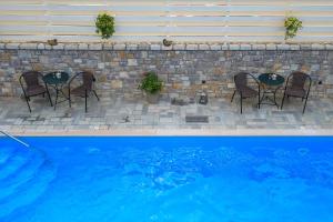 a table and chairs next to a swimming pool at Neda Hotel in Olympia