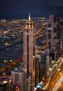 The Tower Plaza Hotel Dubai في دبي: مبنى طويل في مدينة في الليل