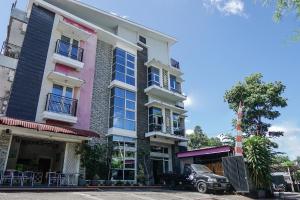 un edificio con un coche aparcado delante de él en OYO 1236 Elite Residence, en Manado