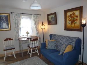 uma sala de estar com um sofá azul e uma mesa em Kitty's em Tullamore