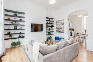 uma sala de estar com um sofá e uma mesa em Bright & Spacious 4beds home - Kensington High Street-Olympia em Londres