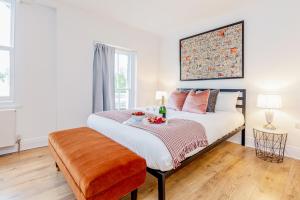 ein Schlafzimmer mit einem großen Bett und Holzboden in der Unterkunft Bright & Spacious 4beds home - Kensington High Street-Olympia in London