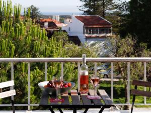 a table with a bowl of fruit and a bottle of wine at Carcavelos Beach&Bike House (view, parking, wi-fi) in Carcavelos