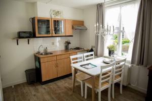 a kitchen with a table and chairs and a sink at Overnachten bij Vergeet me Niet in Blokzijl in Blokzijl