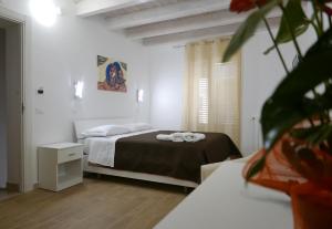 a bedroom with a bed with two towels on it at Opera Boutique Rooms in Monreale