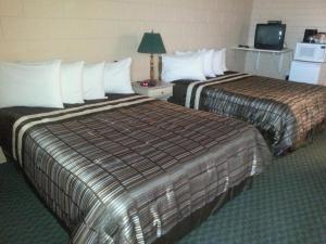 a hotel room with two beds and a television at Maple Leaf Motel Emerson in Emerson