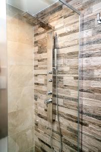 a bathroom with a shower with a stone wall at Your home in Letojanni in Letojanni