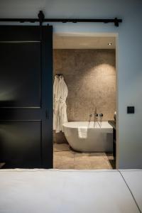 a bathroom with a bath tub and a sink at Boutiquehotel 't Fraeyhuis in Bruges