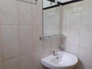 un bagno bianco con lavandino e specchio di Golden Pearl Safari Villa a Udawalawe Altre 93 foto