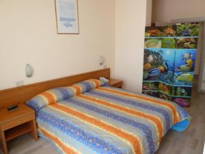 a bedroom with a bed with a colorful blanket on it at Silvi Marina Sea Resort in Silvi Marina
