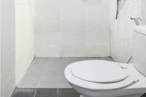 a white bathroom with a toilet and a sink at RedDoorz at Siwalankerto Surabaya in Surabaya +10 photos