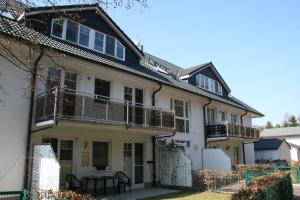 a white house with balconies and a table at Ferienwohnung Sonnenstrand Whg 12 in Thiessow