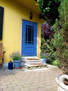 una porta blu sul lato di una casa gialla di Haus im Gruenen a Weilbach