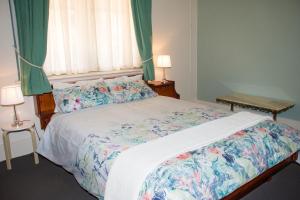 a bedroom with a large bed with a floral bedspread at Kimba Travellers' Haven in Kimba
