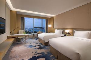 Voodi või voodid majutusasutuse Wyndham Grand Plaza Royale Yuzhou Xiamen Wuyuan Bay toas