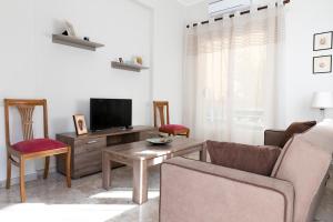 a living room with a tv and a table and chairs at PANOS HOUSE in Kiaton
