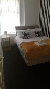 a bedroom with a large bed with a window at Gateshead's Amethyst 3 Bedroom Apt, Sleeps 6 Guests in Gateshead