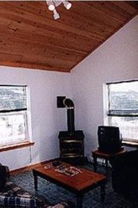 a living room with a stove in the corner of a room at Chisholms of Troy Coastal Cottages in Port Hawkesbury