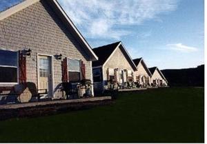 a row of houses with chairs in a yard at Chisholms of Troy Coastal Cottages in Port Hawkesbury