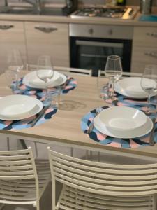 uma mesa com pratos e copos de vinho em Aus Holiday Catania em Catânia